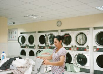 Lavadora de roupas instalada em área de serviço estreita de apartamento compacto