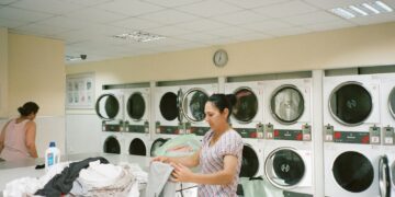 Lavadora de roupas instalada em área de serviço estreita de apartamento compacto