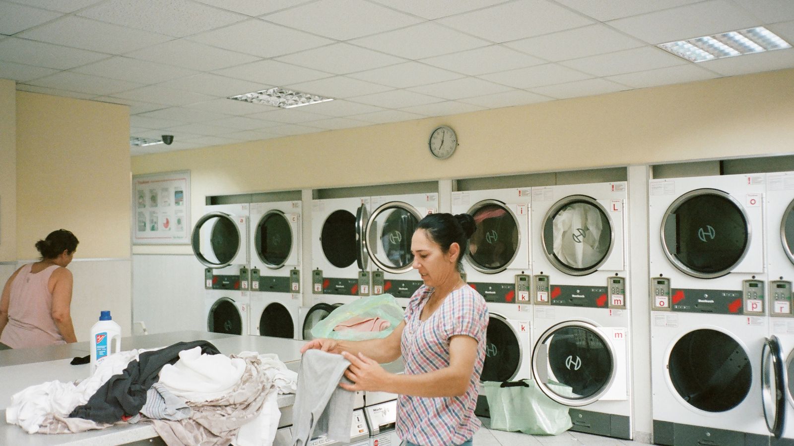 Lavadora de roupas instalada em área de serviço estreita de apartamento compacto